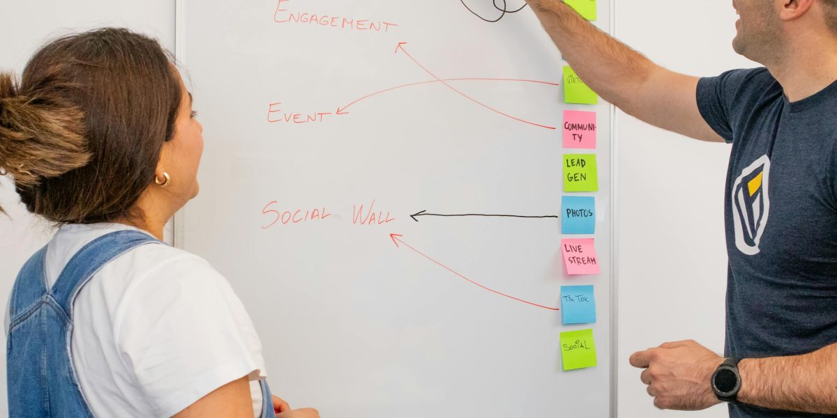 A team collaborating to visualize complex, abstract ideas on a whiteboard, reflecting the challenge of representing AGI.