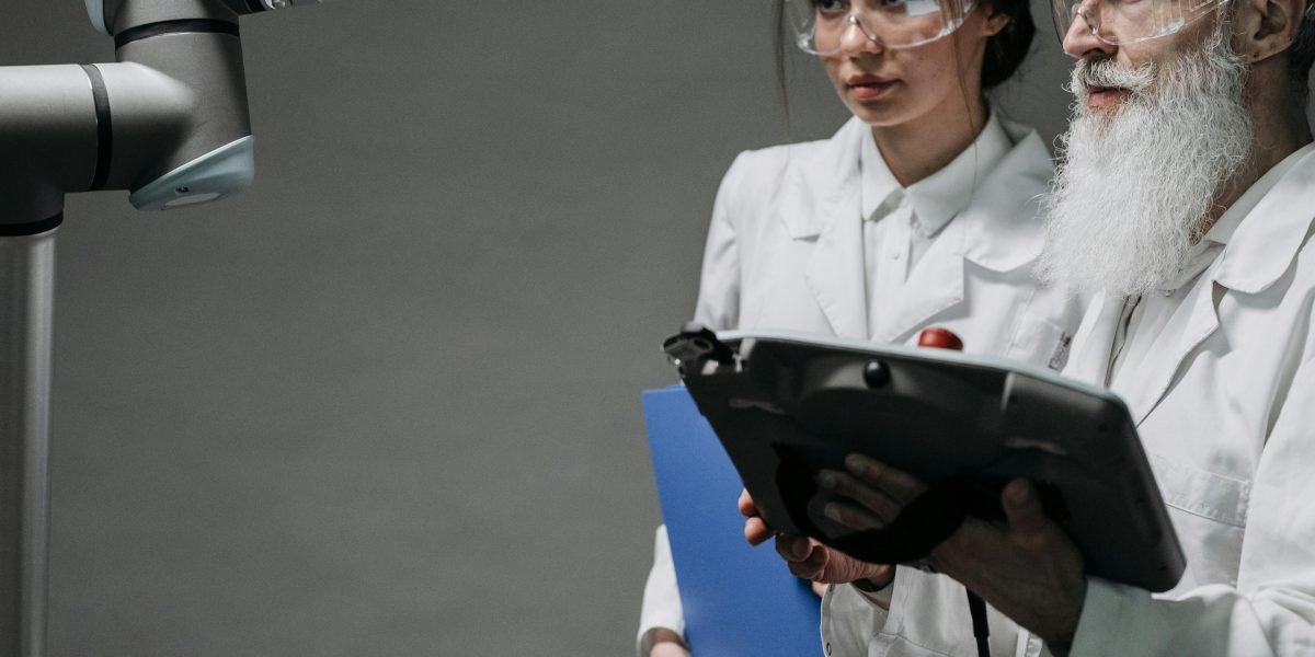 Engineers collaborating in a modern factory setting, observing or working alongside advanced robotic systems, highlighting human-machine teamwork.