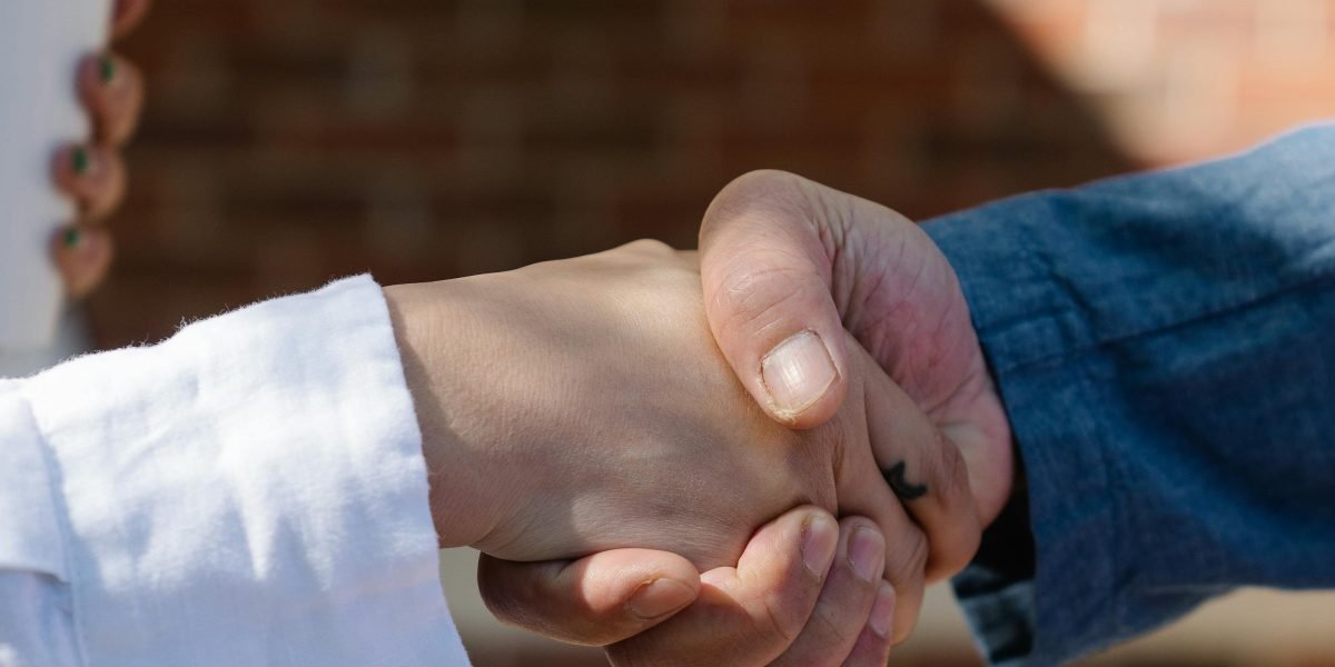 Two professionals shake hands, symbolizing a successful hiring decision for an AI team.
