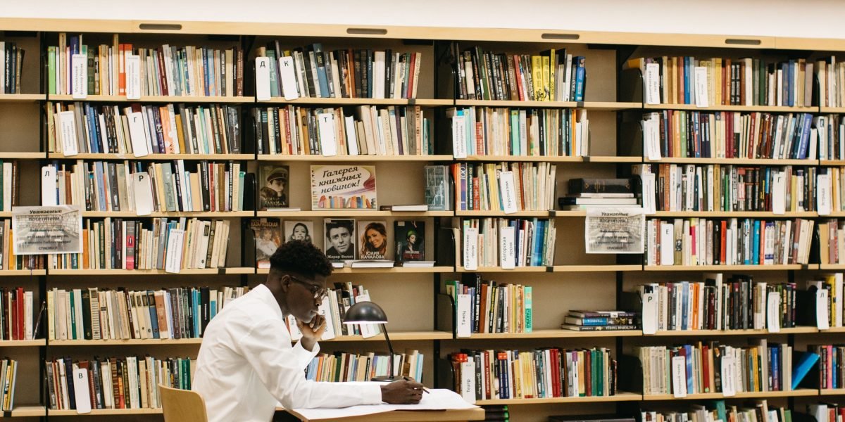 A researcher intently focused on documents and notes in a quiet library setting, symbolizing deep study.