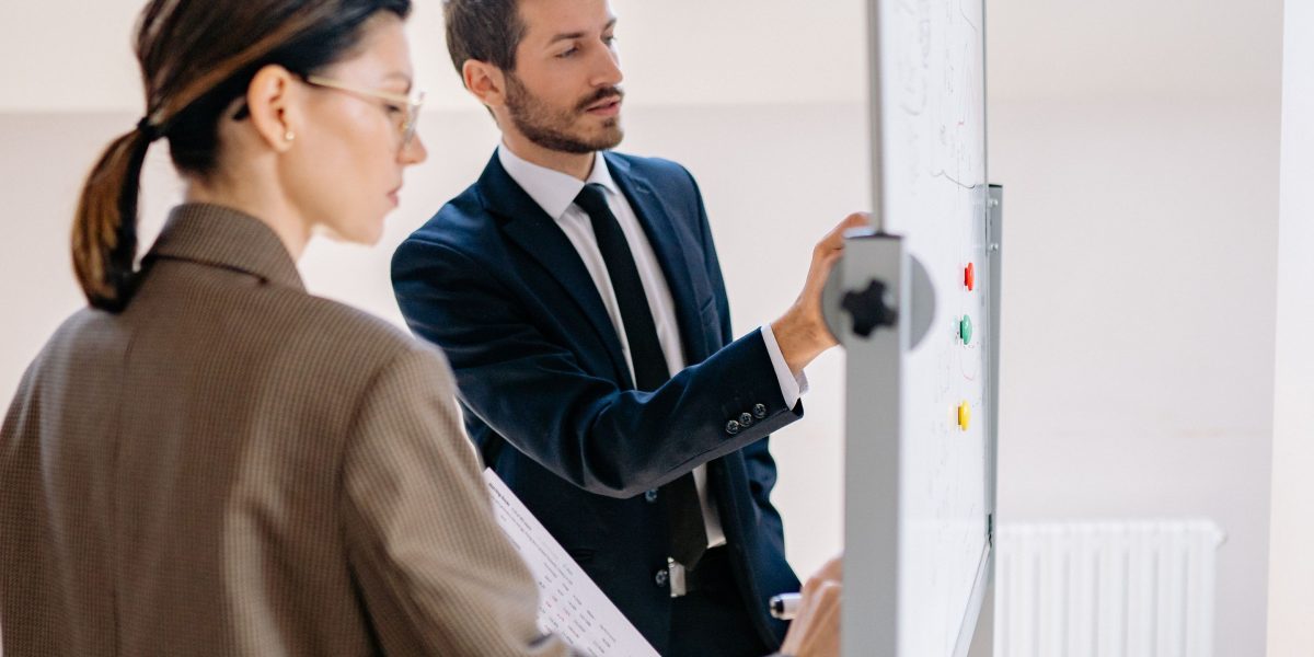 A team actively collaborating at a whiteboard, symbolizing the benefits of AI in understanding large, complex codebases.