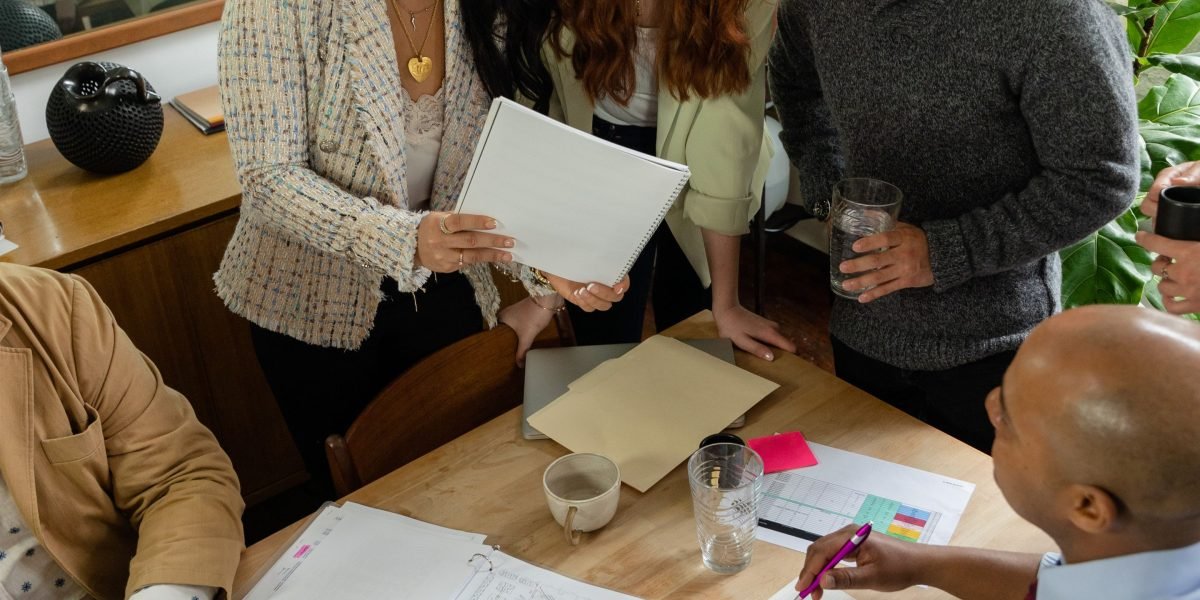 A team reviews documents, symbolizing the implementation of ethical principles and governance frameworks in AI projects.