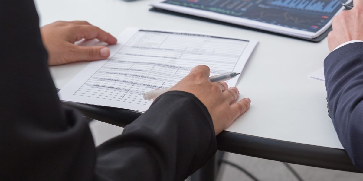 Business professionals meticulously review documents during a due diligence process, ensuring investment readiness.