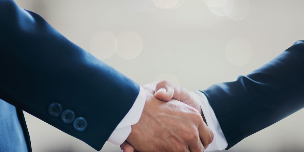 Professionals shaking hands, symbolizing trust, compliance, and agreement on ethical guidelines for AI detector usage and legal adherence.