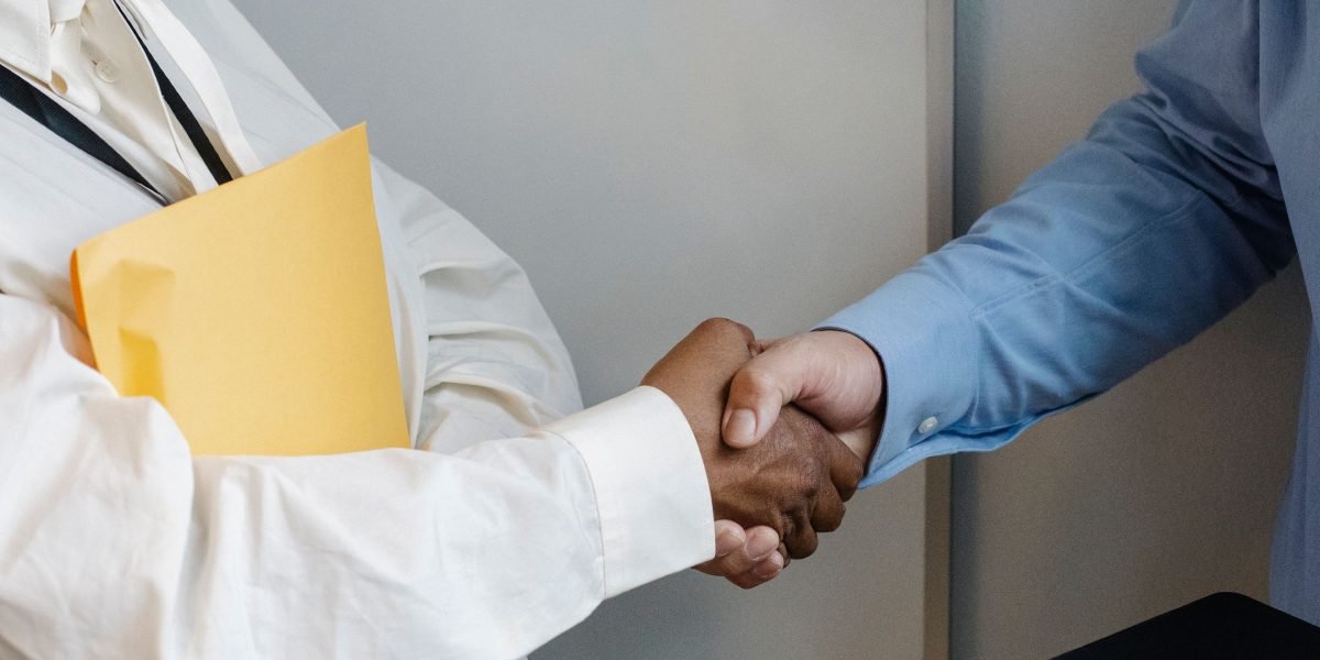 Two professionals shaking hands, signaling a successful meeting or new connection.
