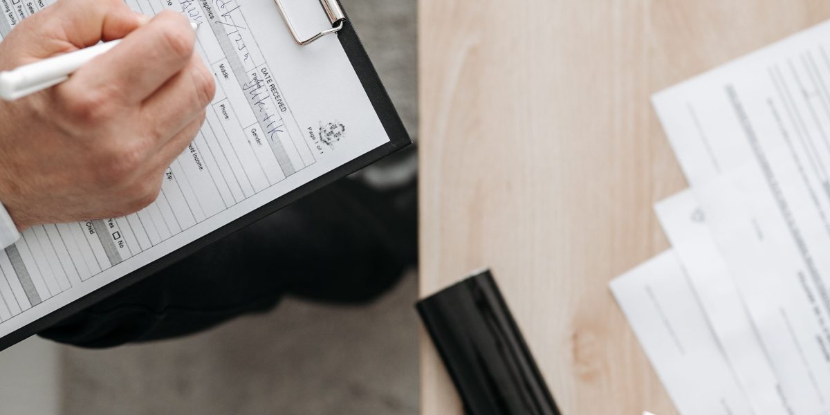 A person meticulously organizing various business documents in preparation for investor due diligence.