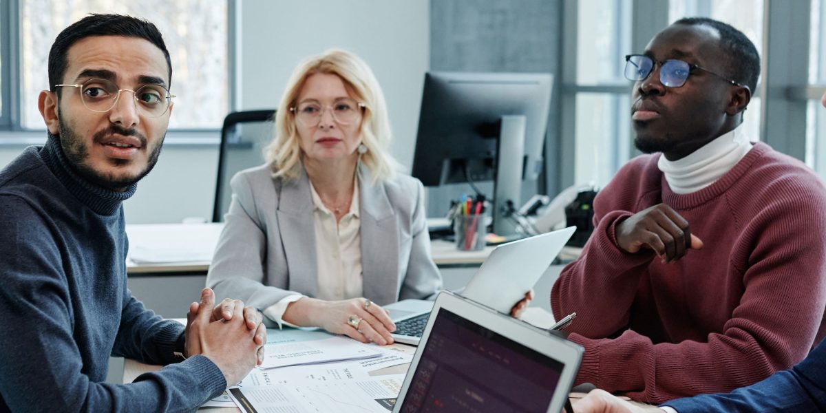 A team of professionals collaborating in an office, discussing complex regulatory changes affecting their investments.